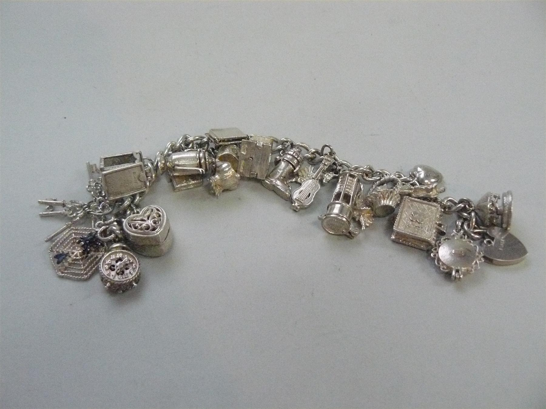 A silver charm bracelet with twenty-one attached charms.