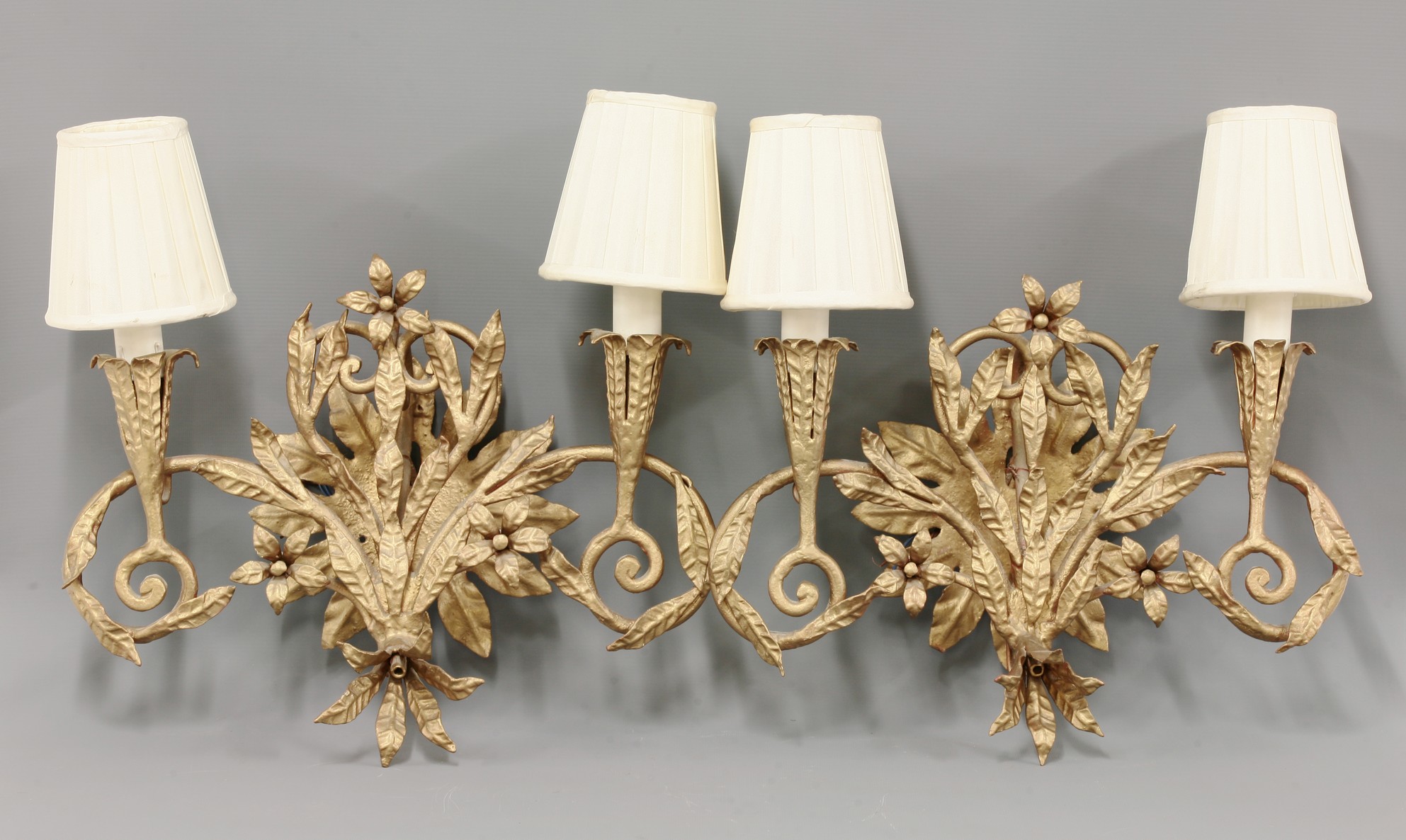 A pair of  twin branch wall lights,
cast with entwined flowering foliage,
32cm high (2) CONDITION