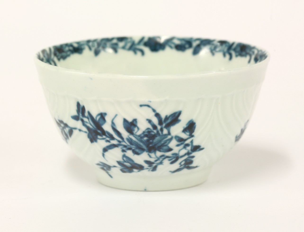 A Worcester Tea Bowl,
c.1765, feather moulded and painted in underglaze blue in the Prunus Root