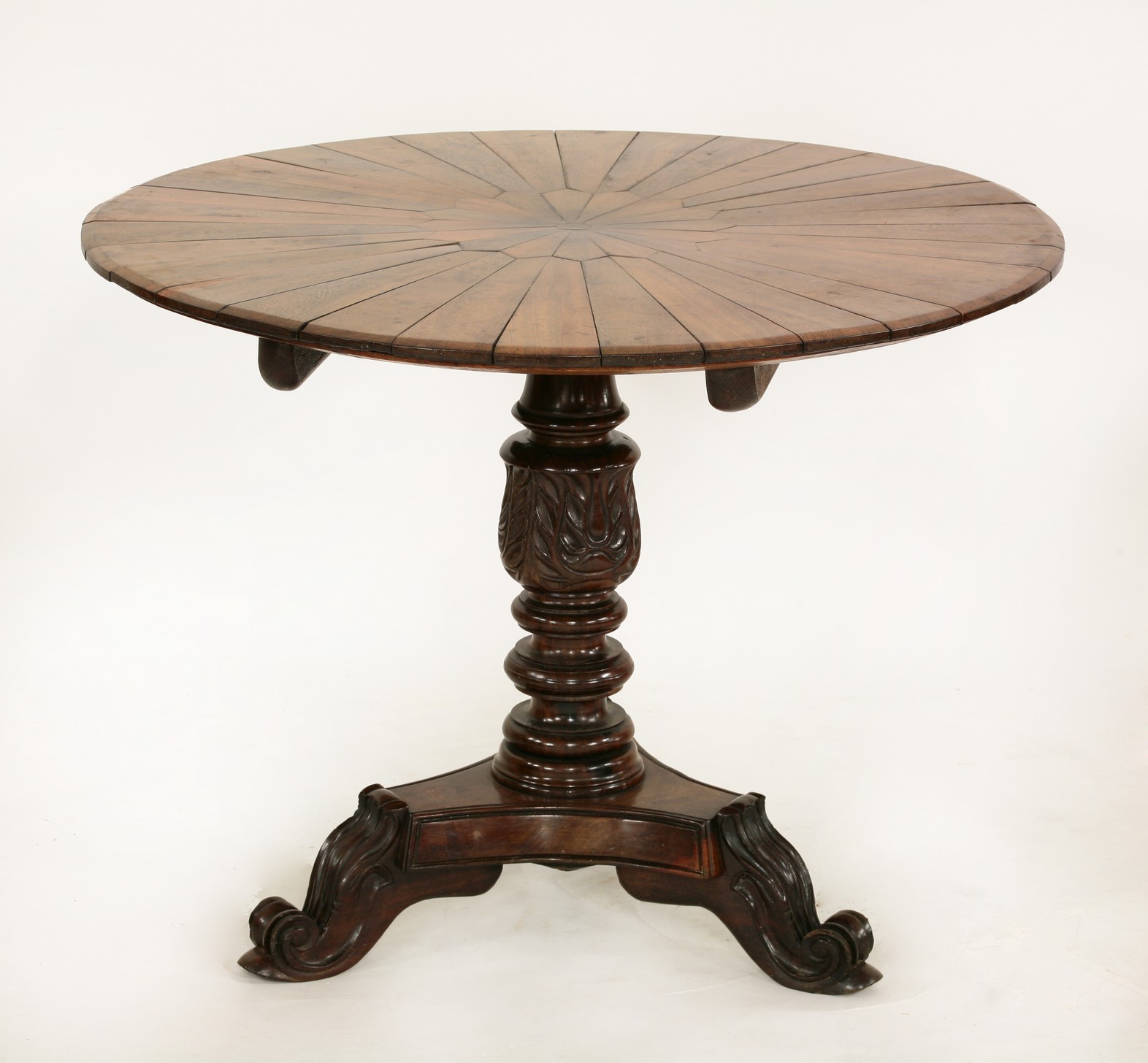 An Anglo Indian carved palmwood table,
19th century, the circular top composed of alternating radial