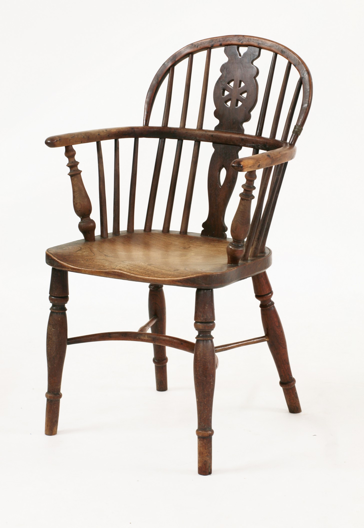 A wood and elm half hoop Windsor armchair, 
19th century, having a wheel back splat and with