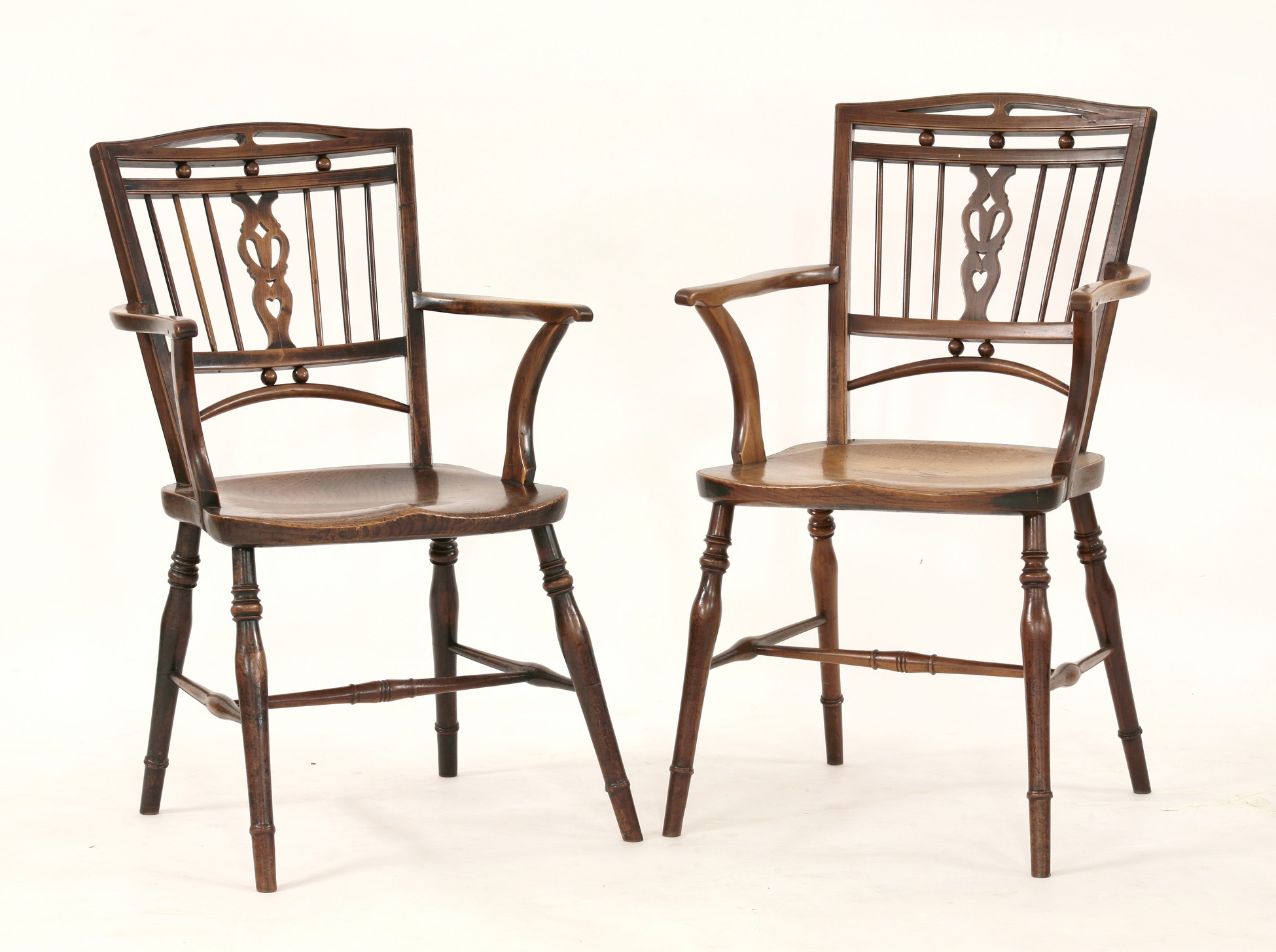 A pair of strung fruitwood Mendlesham chairs,
19th century, with heart-shaped splats and elm