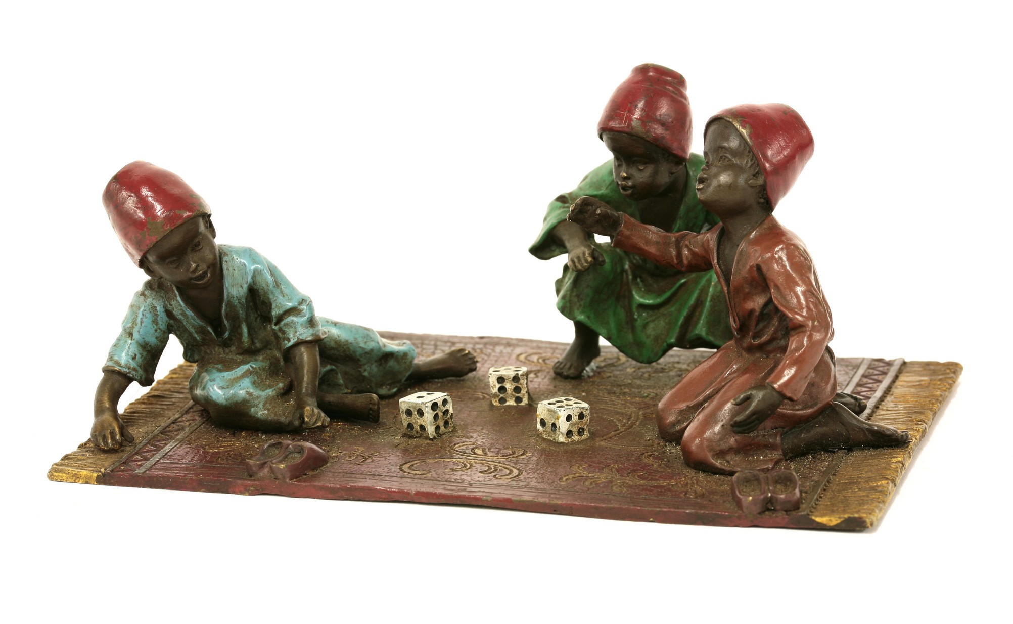 An Austrian cold painted bronze group,
of three children rolling dice on a carpet, by Franz