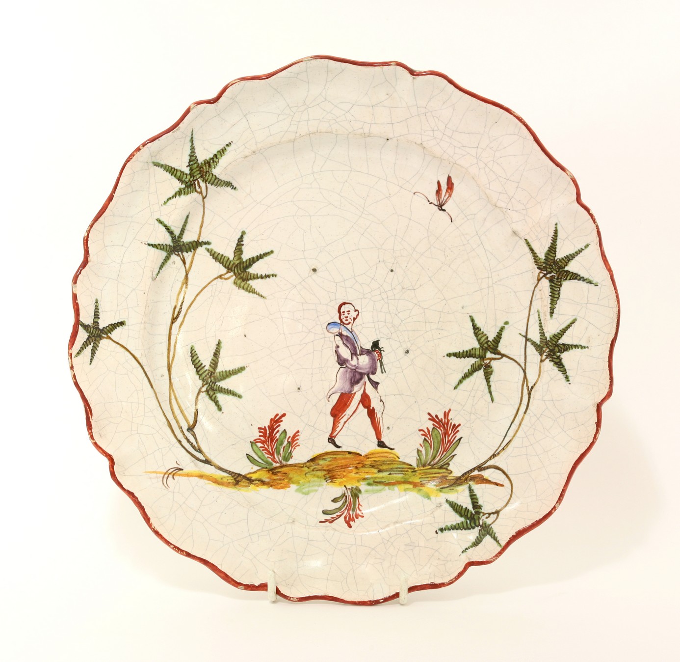 A Milanese Clerici faience Plate,
late 19th century, of shaped form, with red-painted rim and