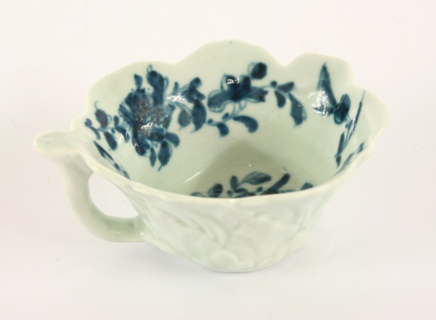 A Worcester blue and white Butter Boat,
c.1765, with over lapping acanthus leaves and stem handle,