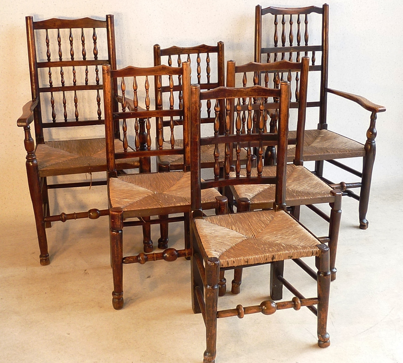 An early 19th Century Harlequin set of six (4+2) Lancashire style spindle back rush seated ash