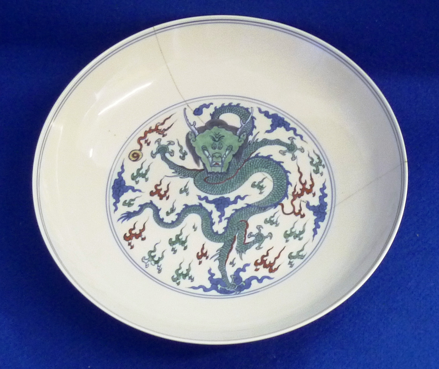 A Chinese porcelain Dish, central decoration in enamels of a green four clawed dragon (facing)