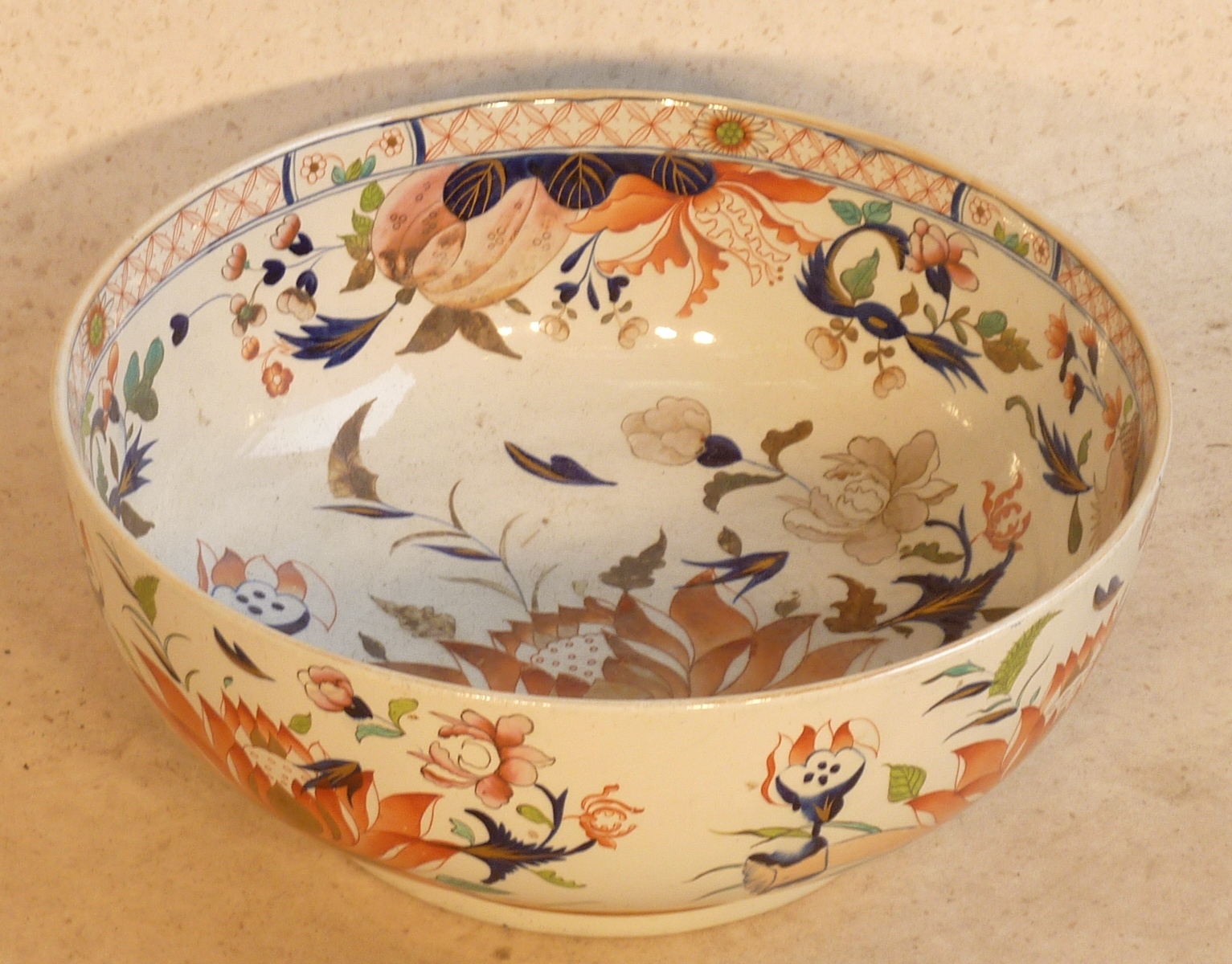 A large circular Japanese porcelain Punch Bowl hand gilded and decorated in the Imari palette with