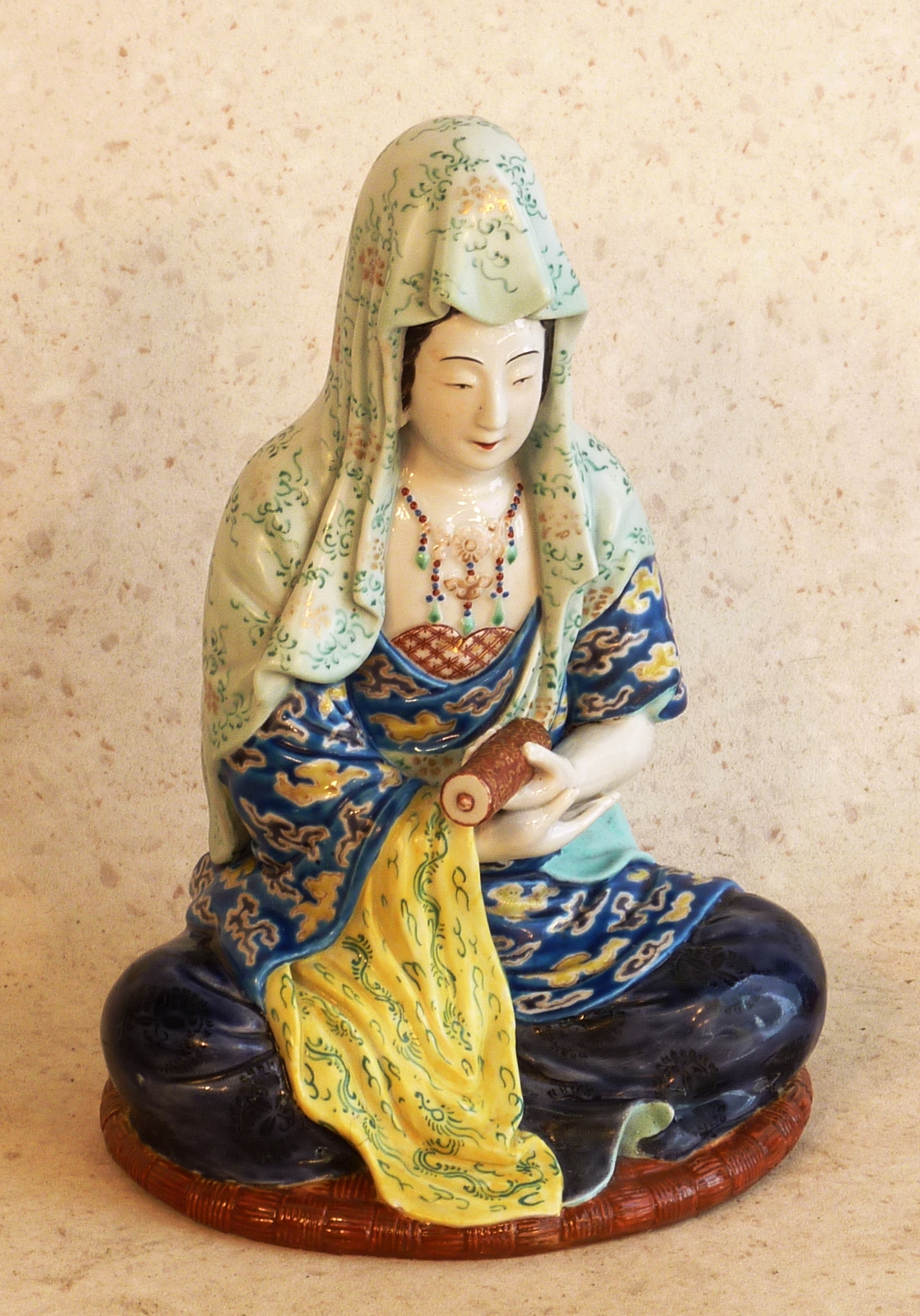 A late 19th Century Oriental seated Figure holding a scroll