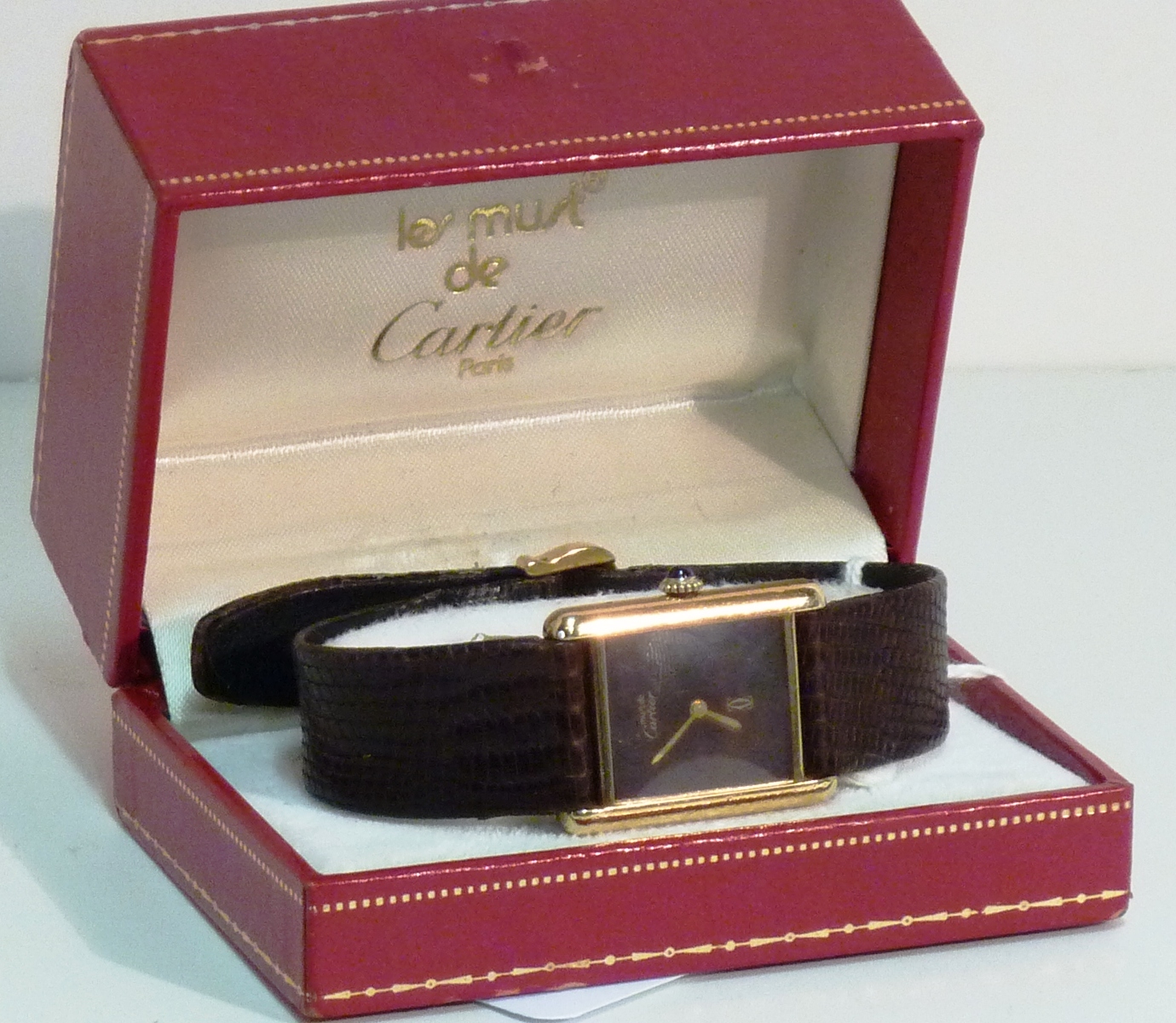 A ladies cased Cartier Tank Watch, plain black rectangular dial signed Must De Cartier gold on