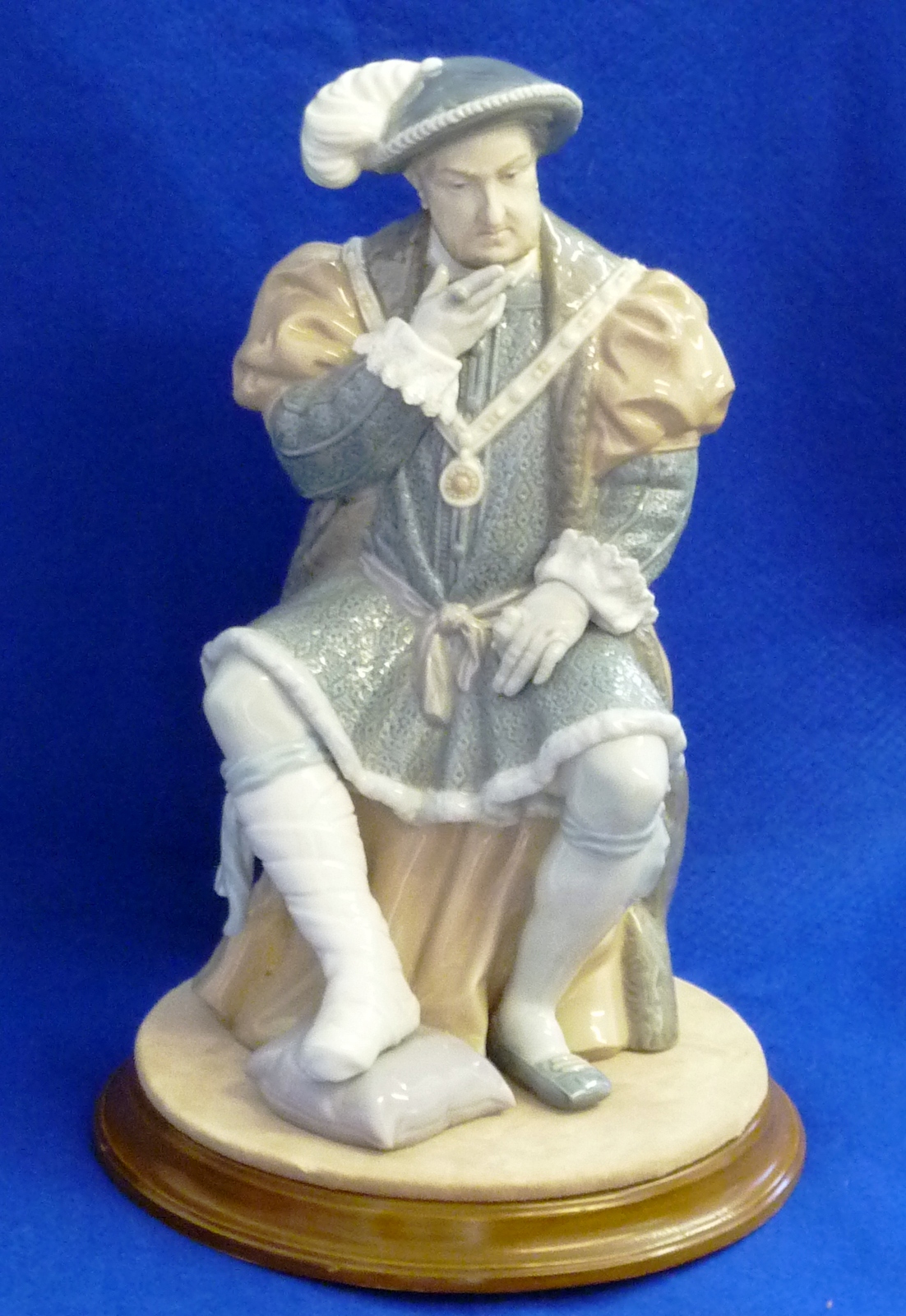 A Lladro Figure of King Henry VIII sitting on a cushioned stool in court dress, decorated in typical