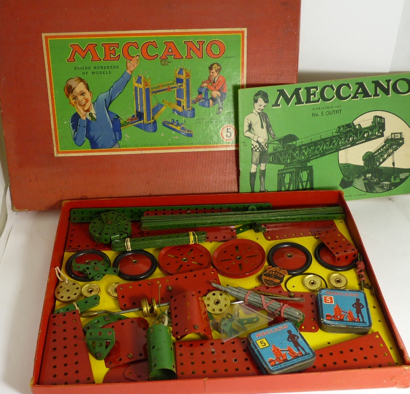 A Meccano set no.5 containing red, green and gold pieces many still attached to inner card, two