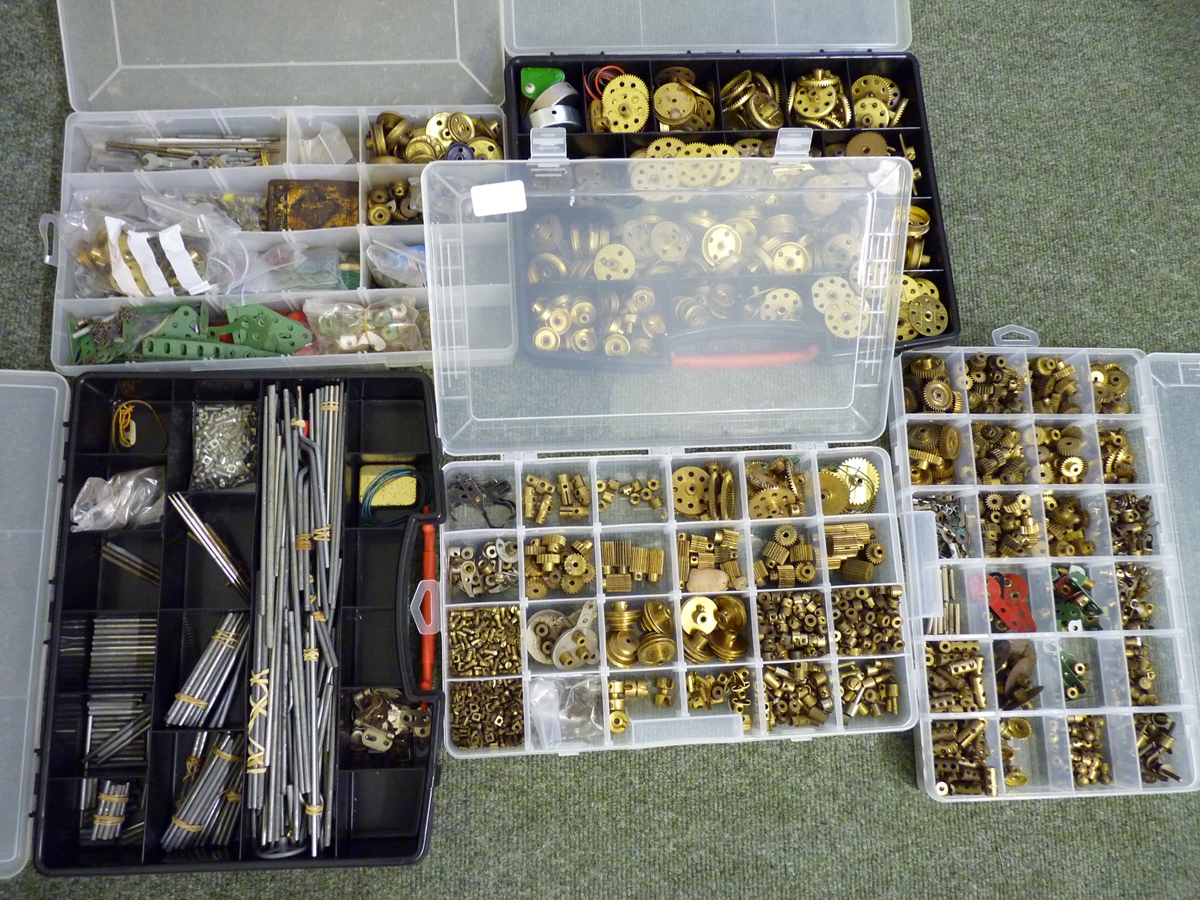A large quantity of Meccano brass screws, cogs, metal rods and other small pieces contained in