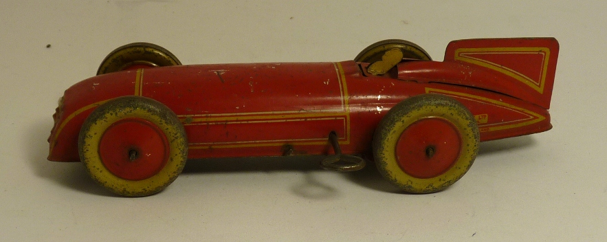 A Burnett Ltd, London tinplate clockwork racing car, red with yellow lining, small driver and simple