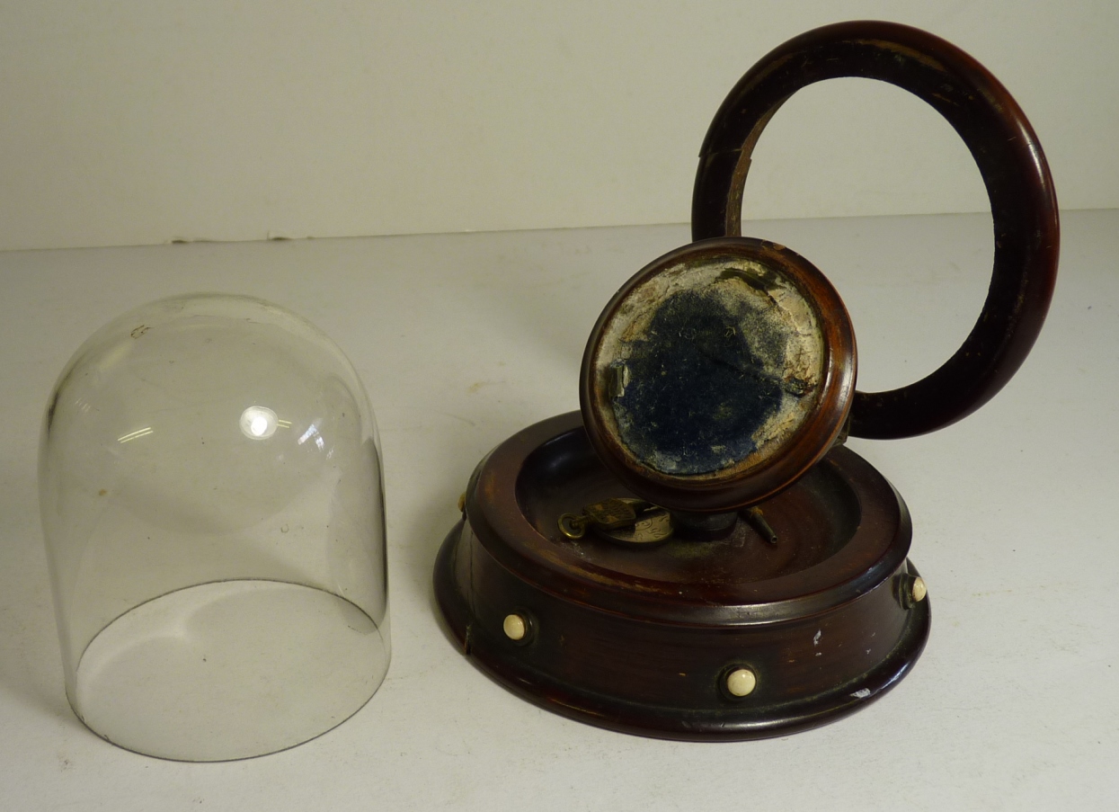 A 19th Century pocket watch stand, polished wood, the base inset with ivory roundels, hinged cover