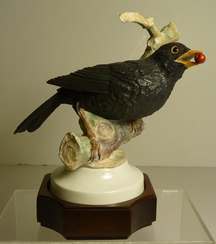 An Abany Fine China limited edition porcelain model of a Blackbird perching on a branch and with a