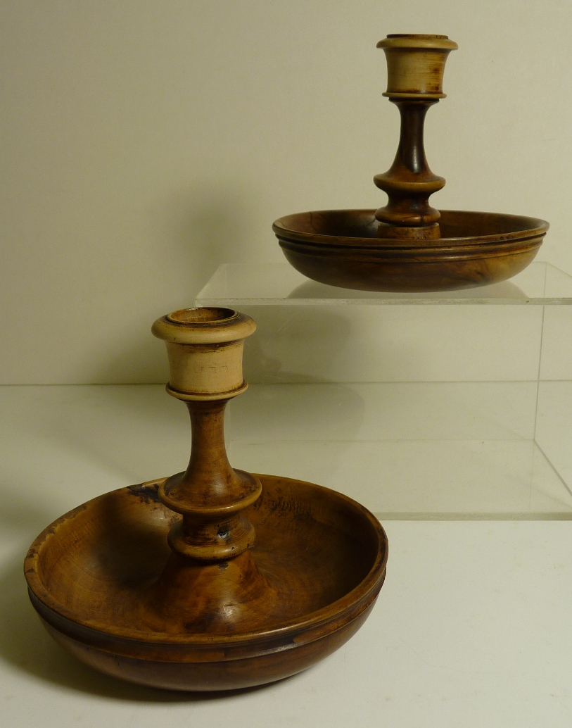 A pair of treen candlesticks, each having short turned stem and deep circular base, the stems