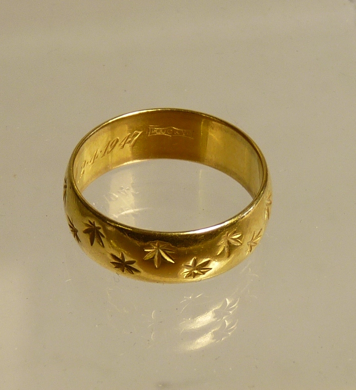 A 22ct gold wedding band with engraved decoration, 6.4g