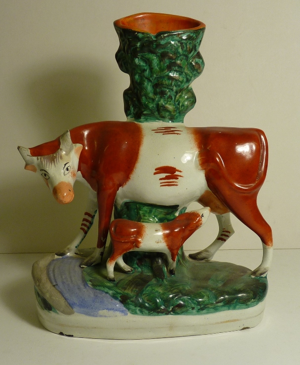 A 19th Century Staffordshire spill vase modelled as a cow suckling a calf, 27.5cms high