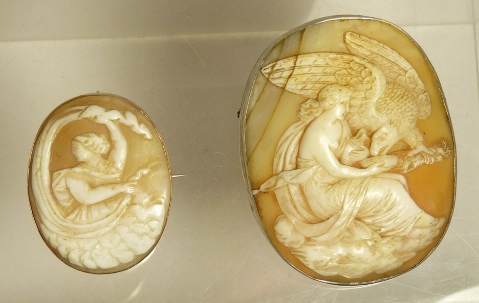 A 19th Century cameo brooch the shell carved as Hebe feeding Zeus as an eagle together with
