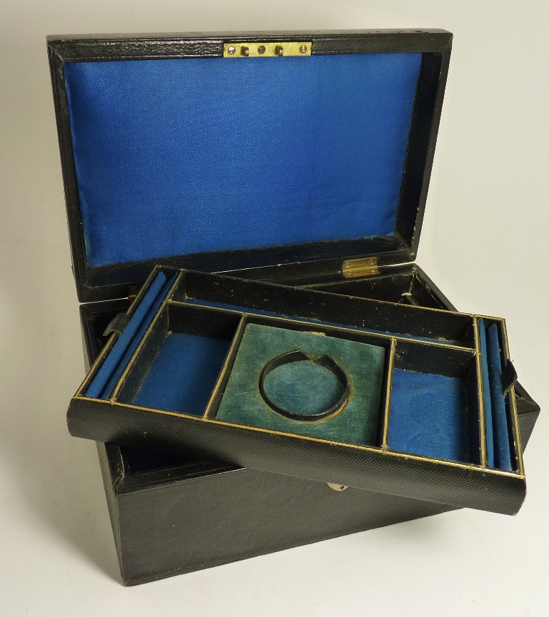 An early 20th Century leather covered jewellery casket with folding carrying handle, with original