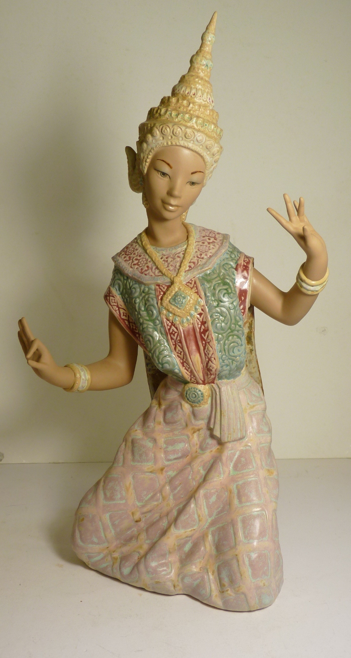 A Lladro figure of a kneeling Thai dancer in traditional costume, with blue factory mark to base,