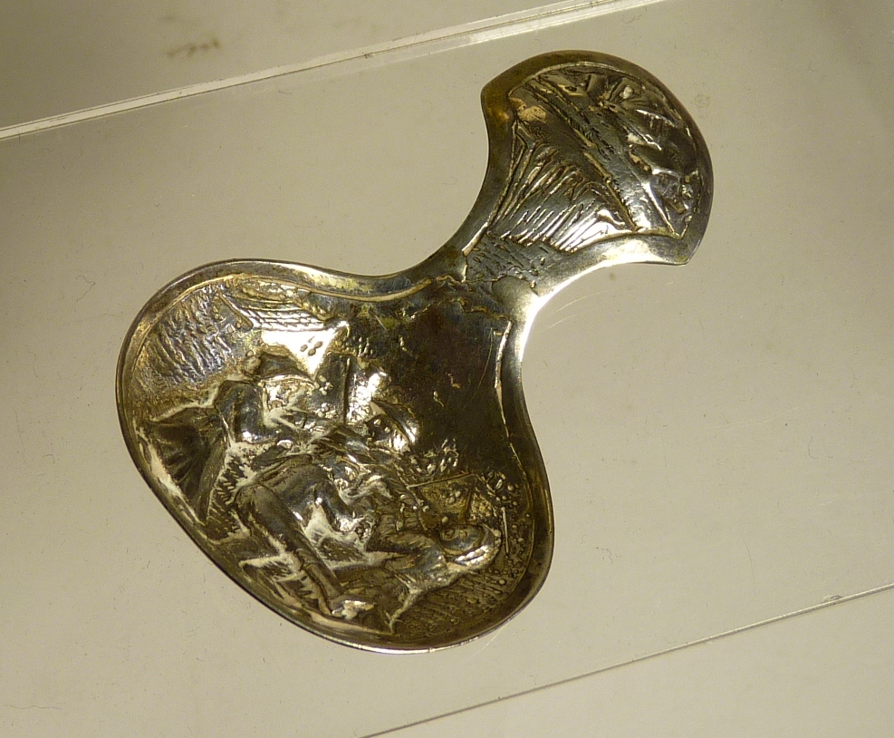 A Dutch silver caddy spoon the bowl embossed with group of dancers, unmarked but tests as silver