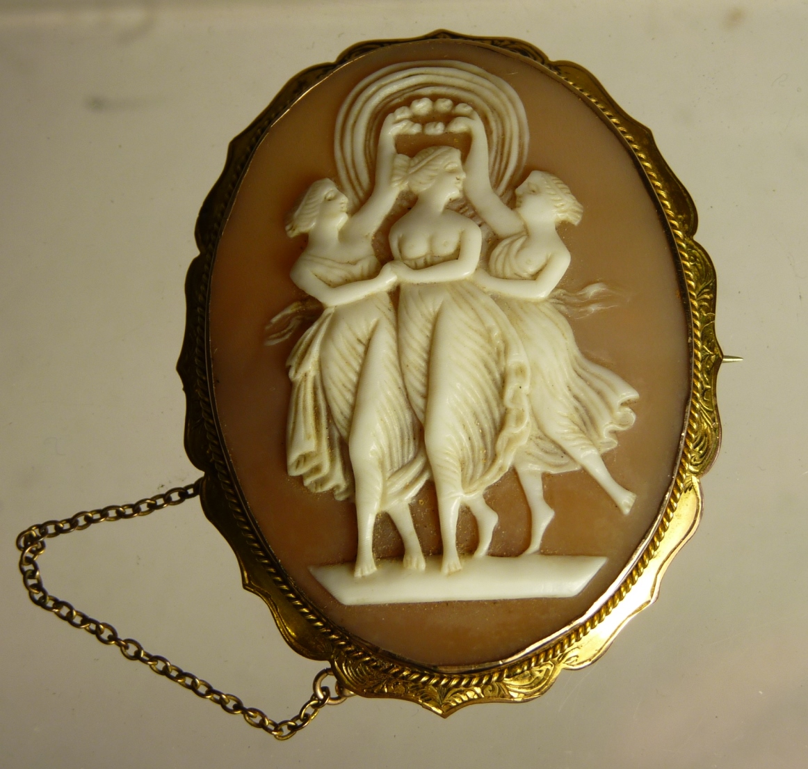 A Victorian 9ct gold set cameo brooch, the central oval shell carved with the Three Graces, 6cms x