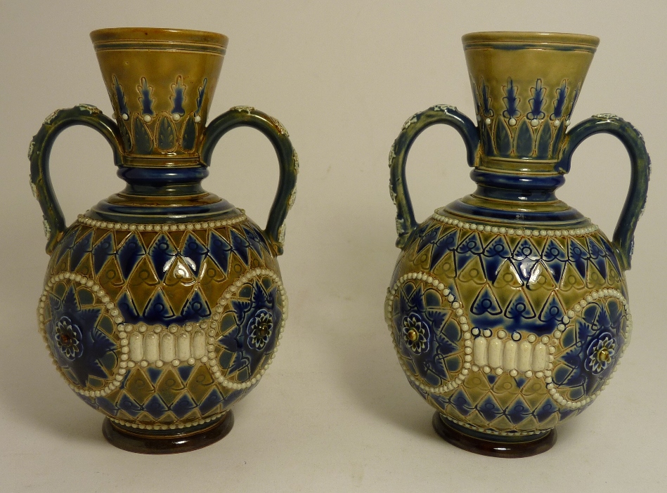 A pair of Doulton Lambeth stoneware two handled vases with incised and applied geometric decoration,