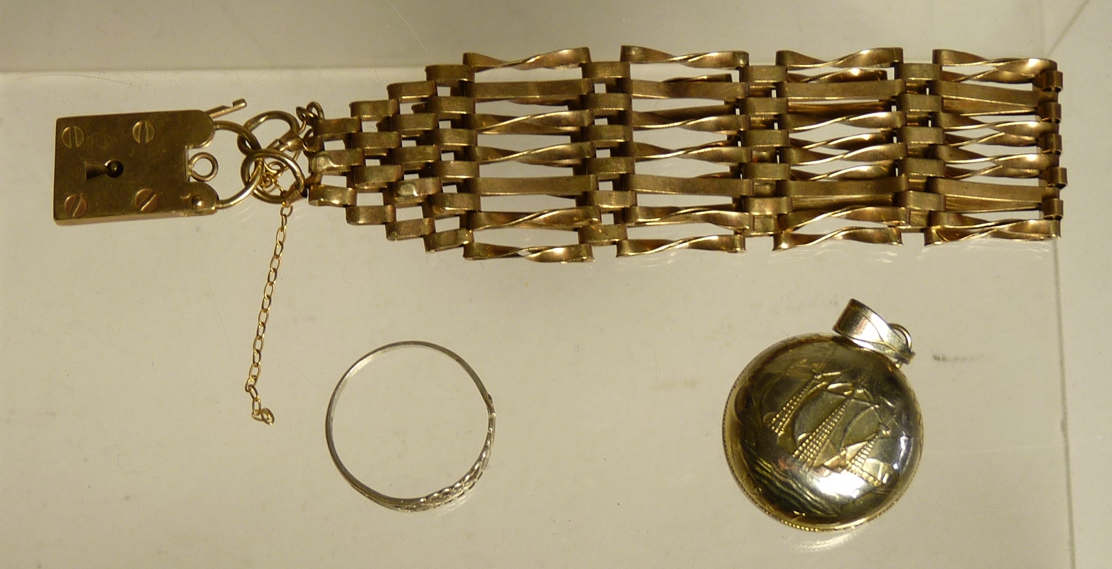 A 9ct rose gold gatelink bracelet with padlock clasp, 14.2g, a small silver ring and a gilded coin