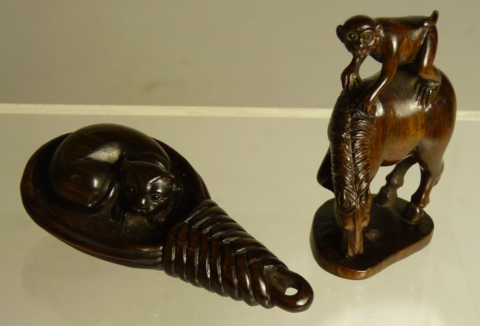 A Japanese carved wood netsuke of a monkey sitting on a horse, scratched character marks to base