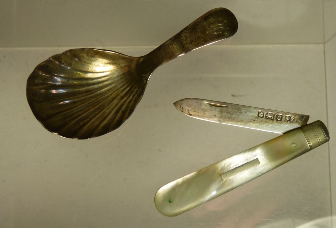 An early 19th Century silver caddy spoon with shell bowl together with a mother of pearl and