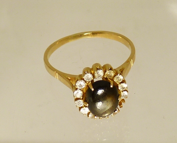 A ladies gold (tested) dress ring, set with a central circular cabochon labradorite with a