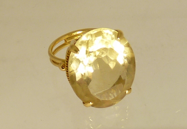A gold (tested) citrine set dress ring, the ring set with a large oval faceted citrine in a gold