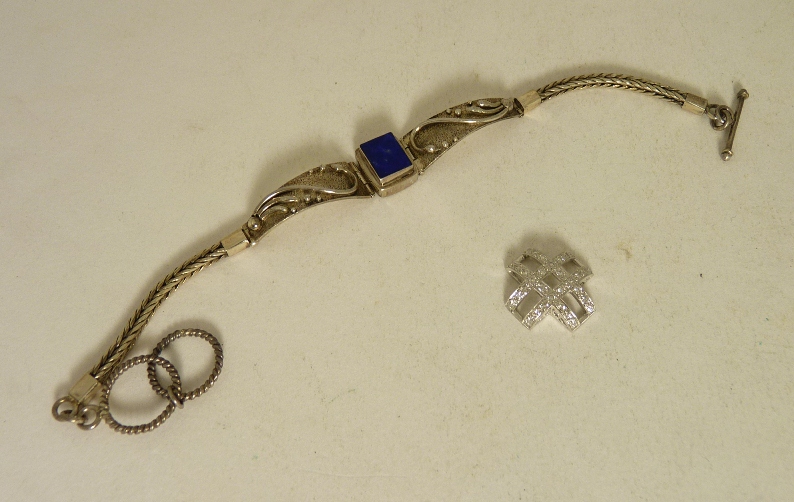 An 18ct white gold diamond set openwork cross (possibly a mount) and a 925 silver bracelet inset