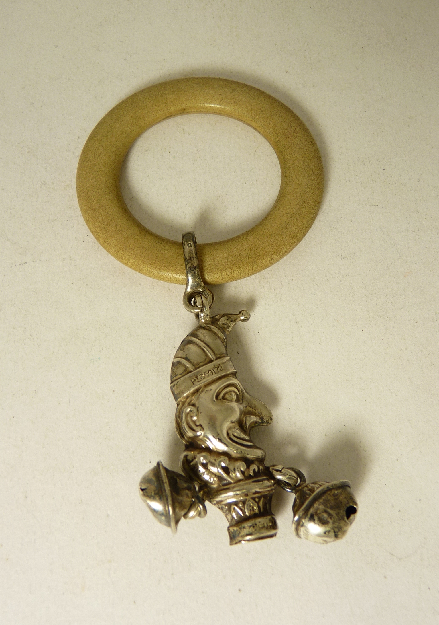 A late 19th/early 20th Century baby`s teether/rattle, the composition ring suspended with hollow
