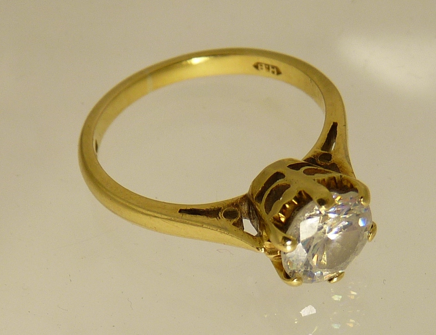 An 18ct gold solitair ring set with a central circular clear faceted stone (possibly clear topaz) in