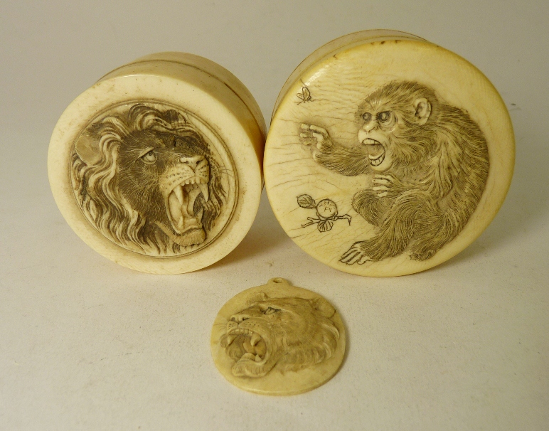 A Japanese circular ivory box, the cover carved with a snarling lion; another similar carved with