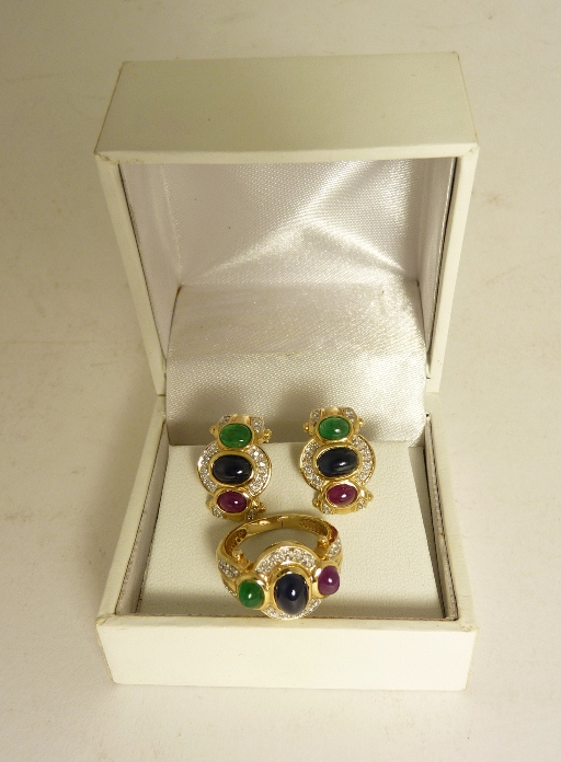 A 14ct gold ring set with cabochon central sapphire with ruby and emerald to either side and studded