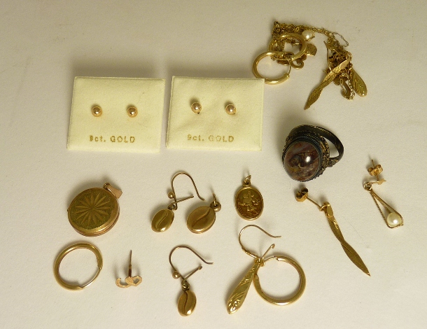 A small circular 9ct gold locket; assorted gold metal pierced earrings; small oval 9ct gold St.