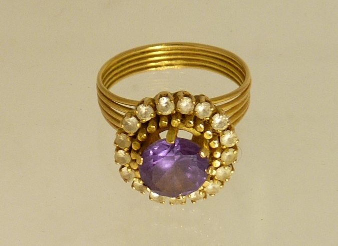 A ladies gold (tested) dress ring, set with a central circular faceted colour-changing stone with