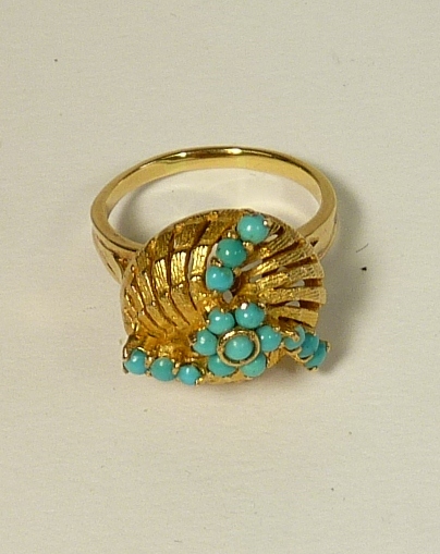 A gold (tested) ladies dress ring, the ring circular gold ribbed with spiral turquoise set