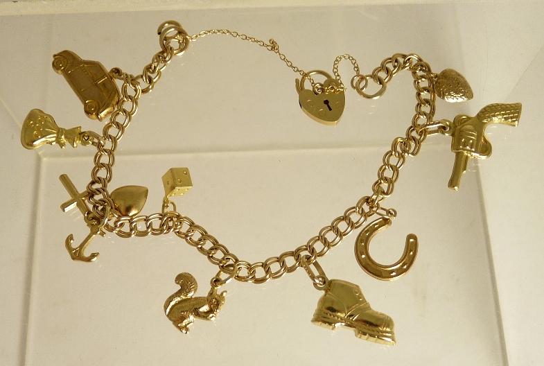 A 9ct gold charm bracelet with various 9ct gold attached charms including a squirrel, a pistol, a
