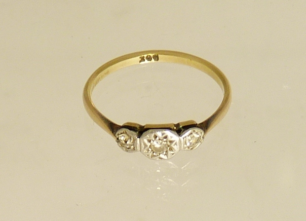 A 9ct gold illusion-set three-stone diamond ring with openwork mounts, size M.