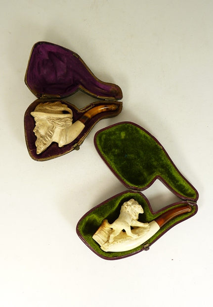 A meerschaum cheroot holder carved with a lion and in original case, together with another carved