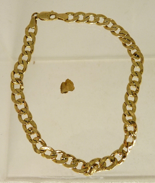 A 9ct gold hollow flat link bracelet 3.5g approx and a gold dental filling 0.4g approx.