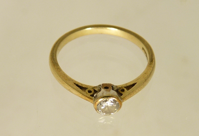 A 9ct gold solitaire diamond ring in open work mount, the diamond in a collet setting. The diamond