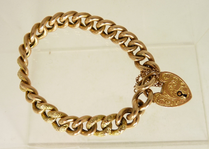 A 9ct gold padlock hollow link bracelet, the double links alternately decorated with pressed