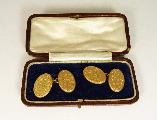 A pair of gents, cased, 18ct gold cufflinks, the oval panels with engraved floral decoration 6.8g