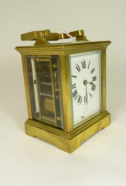 A brass cased carriage clock, the French Movement striking on a gong. The white enamelled dial